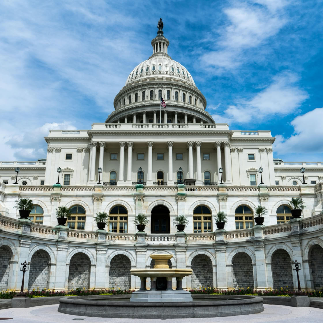 Exterior view of the iconic US Capitol Building on a sunny day in Washington, DC.